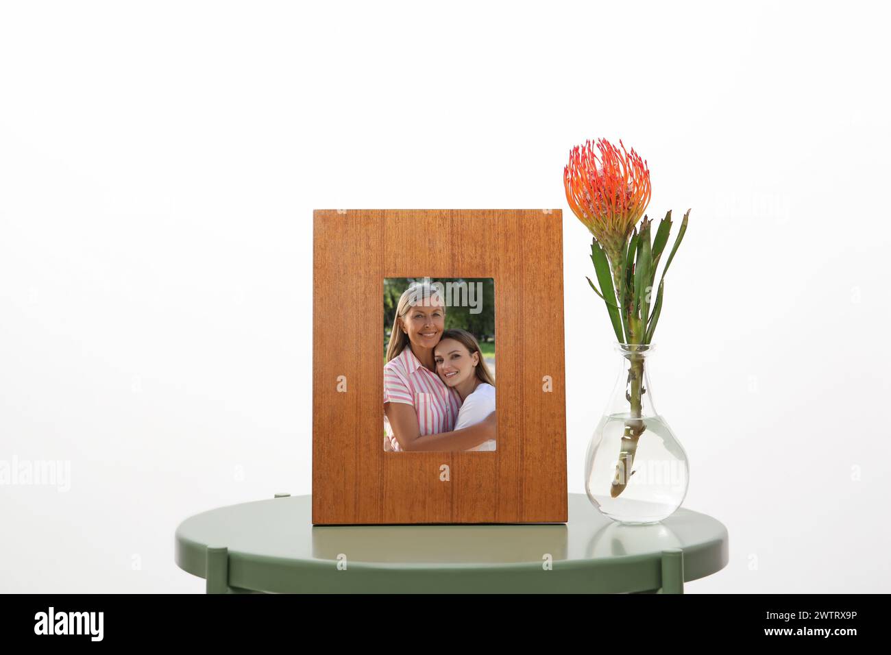 Familienporträt von Mutter und Tochter im Bilderrahmen auf Tisch vor weißem Hintergrund Stockfoto