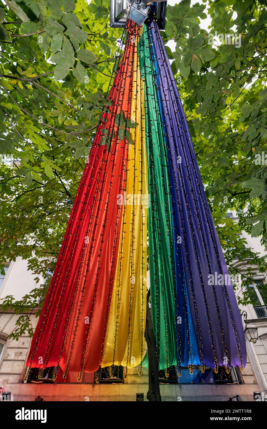 Homosexueller Stolz. Riesige Regenbogenfahne, die die LGBTQIA-Gemeinschaft symbolisiert, die über der Straße des Schwulendorfes im Viertel Le Marais, Paris, Frankreich, Europa hängt Stockfoto