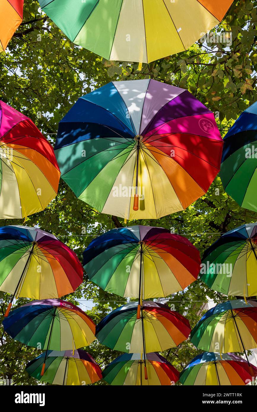 Homosexueller Stolz. Bunte Regenschirme mit Regenbogenfarben, die die LGBTQIA-Community symbolisieren, hängen über der Straße des Schwulendorfes. Paris, Frankreich Stockfoto