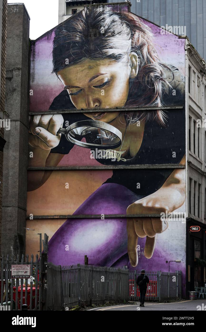 Die Leute gehen an einem Wandgemälde mit dem Titel "Schatz, ich schrumpfte die Kinder" vorbei, an einem Gebäude im Stadtzentrum von Glasgow. Gemalt von dem Künstler Smug (Sam Bates). Stockfoto