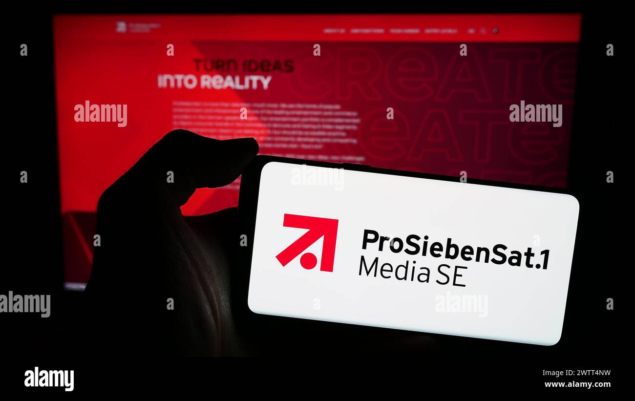 Person mit Smartphone mit Logo der deutschen Fernsehgesellschaft ProSiebenSat.1 Media SE vor der Website. Schwerpunkt auf dem Display des Telefons. Stockfoto
