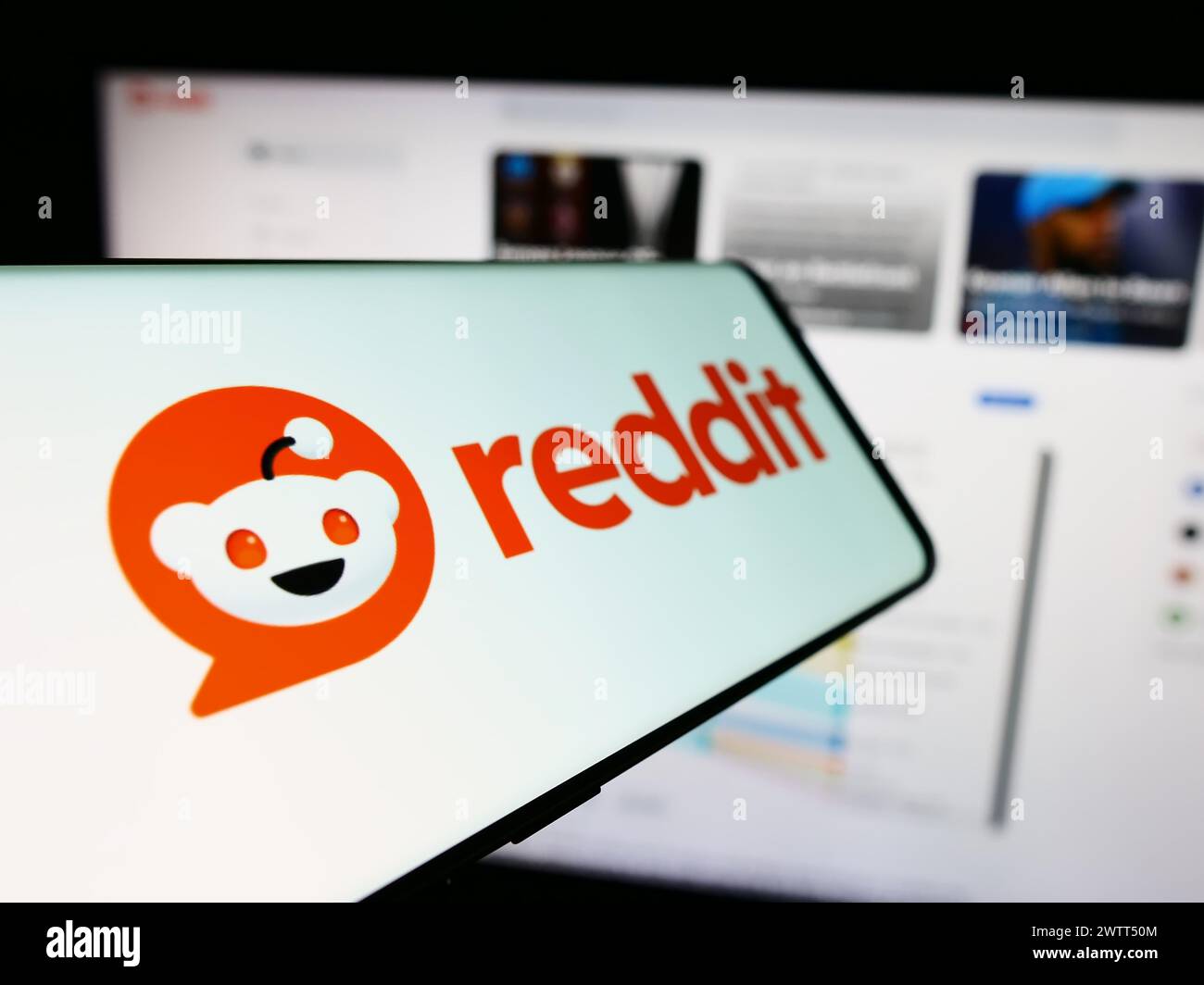 Smartphone mit Logo des amerikanischen Social-Media-Unternehmens Reddit Inc. Vor der Business-Website. Fokus auf der linken Seite des Telefondisplays. Stockfoto
