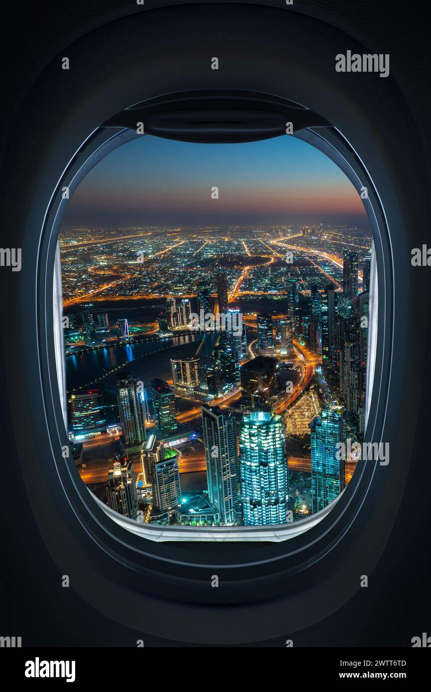 Landung in Dubai, Flug nach Dubai, Blick aus der Luft auf die Skyline der Stadt bei Nacht beleuchtet, Blick aus dem Fenster eines Flugzeugs von innen Stockfoto