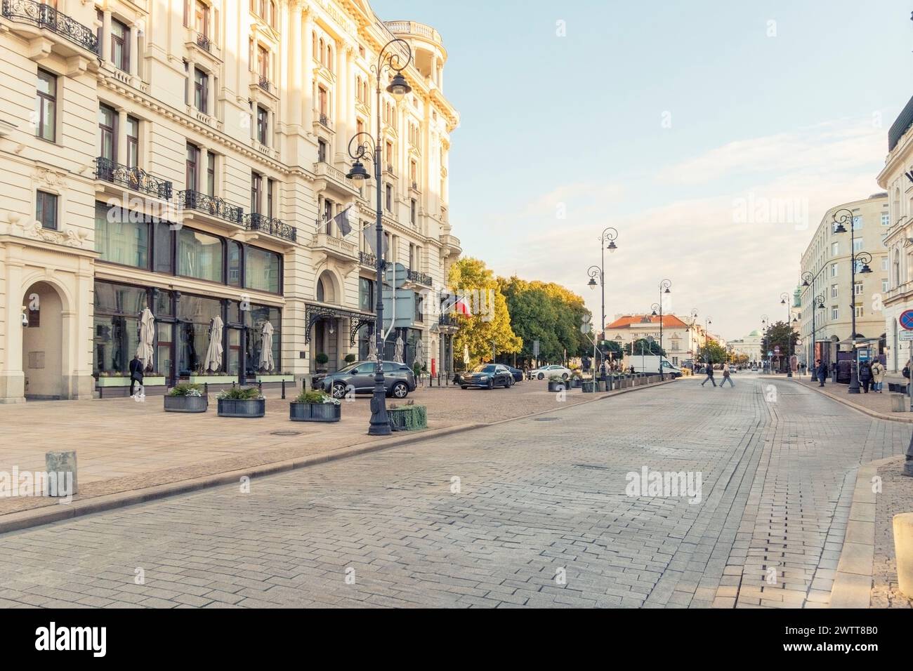 Die Golden Hour erstrahlt in einer eleganten Stadtstraße, die von klassischer Architektur gesäumt ist Stockfoto