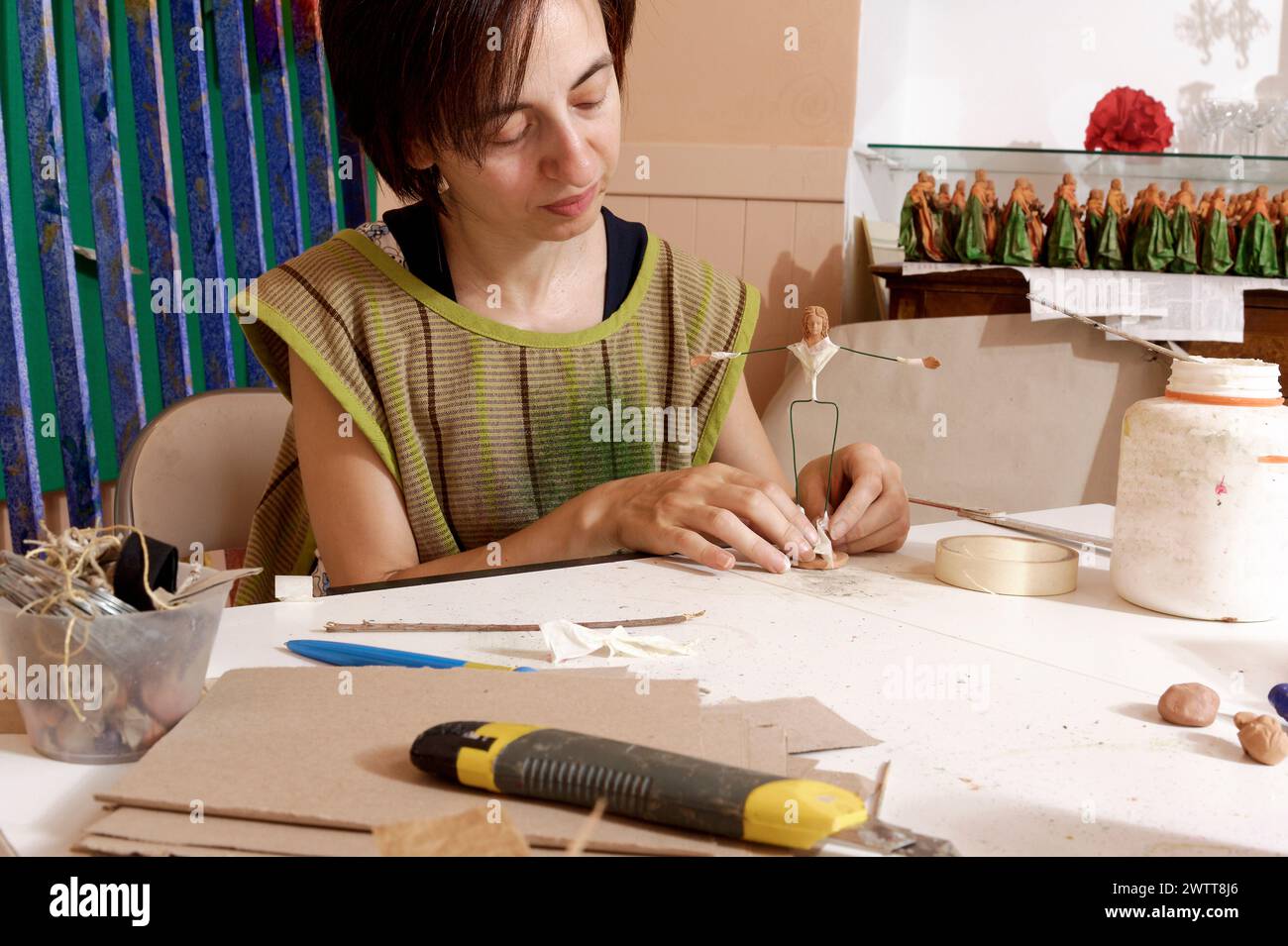 Eine Künstlerin, die in ihrem Atelier eine zarte Skulptur herstellt. Stockfoto