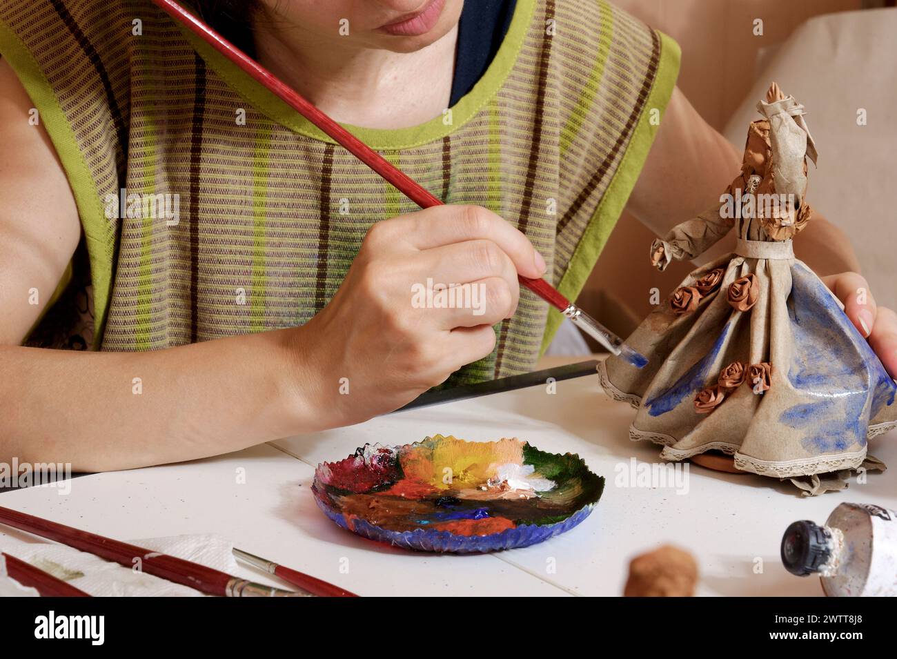 Der Künstler konzentriert sich intensiv auf das Malen einer Figur vor einem neutralen Hintergrund. Stockfoto