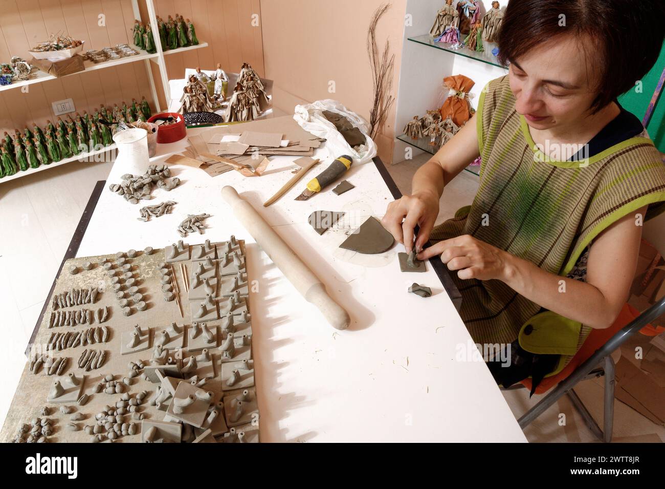 Die Künstlerin bastelt in ihrer Werkstatt akribisch Tonfiguren. Stockfoto
