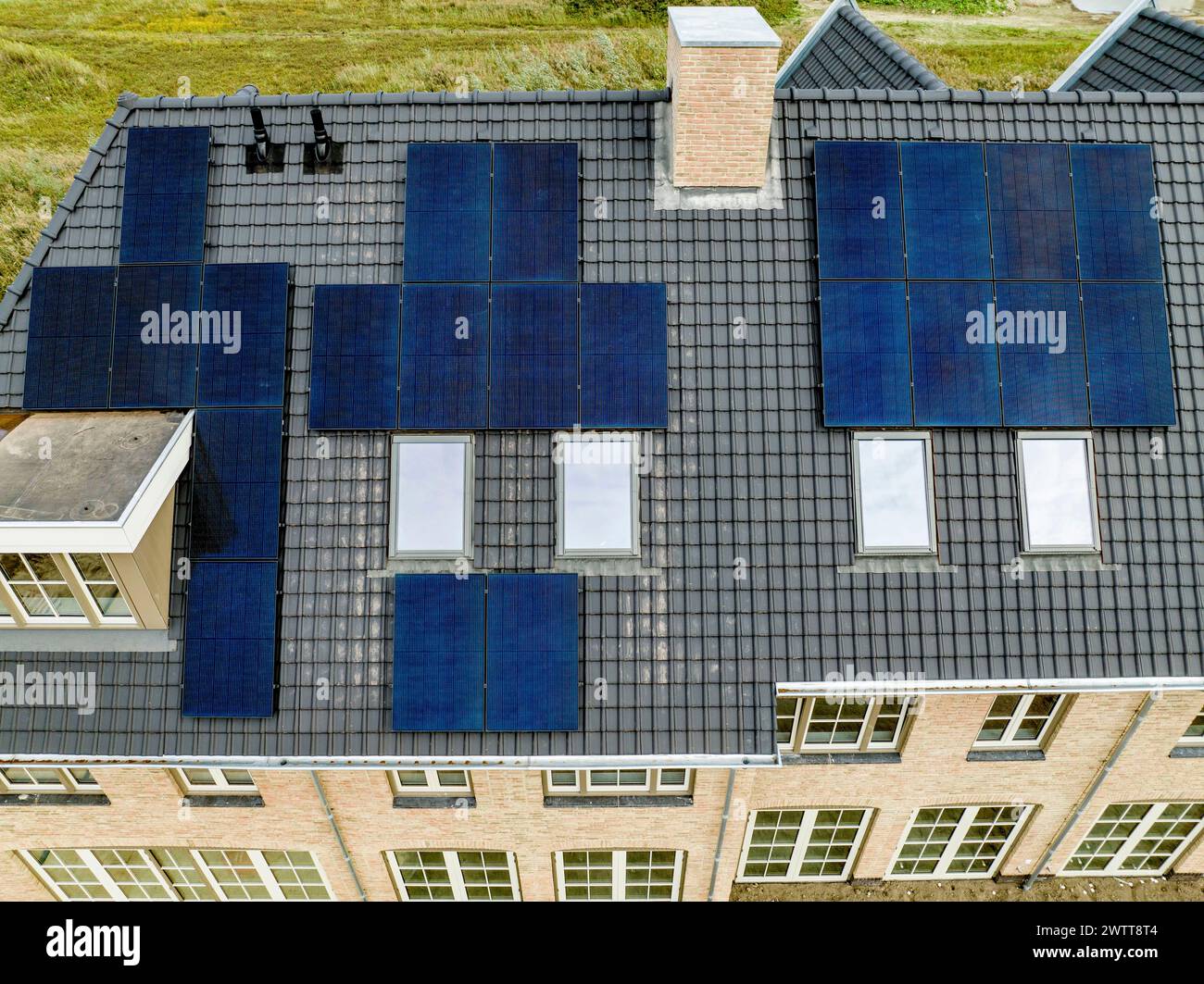 Blick aus der Vogelperspektive auf das Dach eines Wohnhauses mit Solarpaneelen Stockfoto