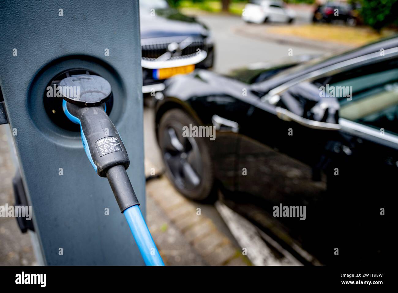 Elektroauto angeschlossen und an einer Straßenstation aufgeladen. Stockfoto