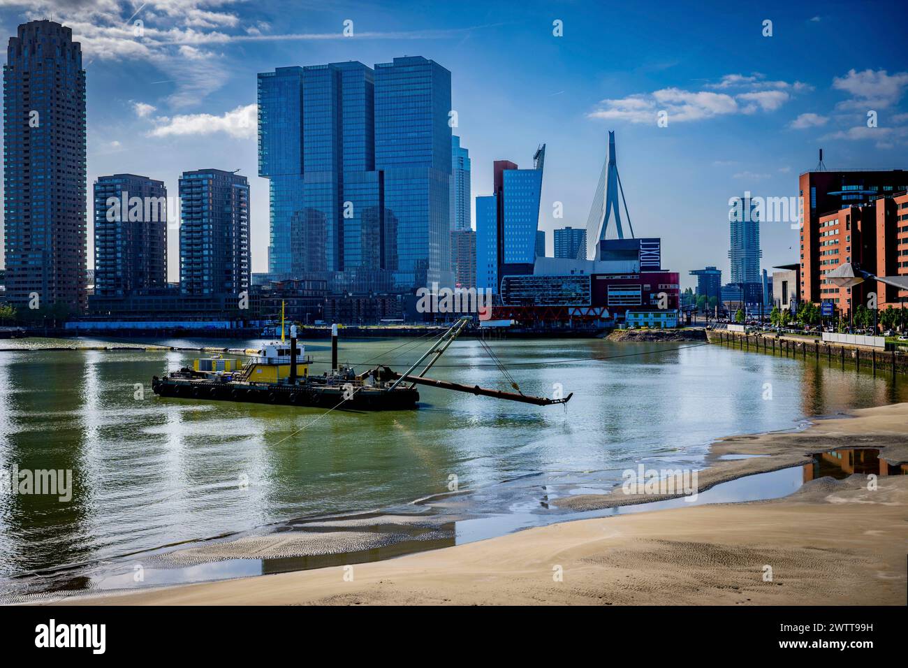 Die geschäftige Skyline der Stadt vor einem klaren blauen Himmel mit einem Schlepper auf dem Fluss Stockfoto