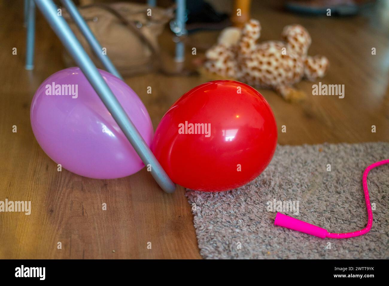Bunte Ballons und Partyreste auf einem Holzboden. Stockfoto