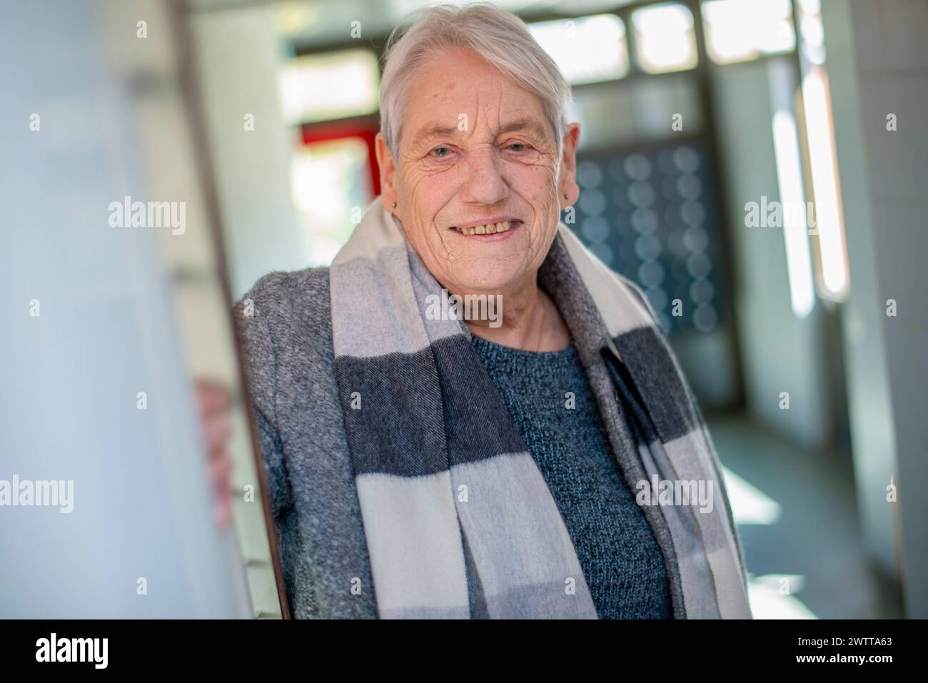 Ältere Frau, die drinnen warm lächelt Stockfoto