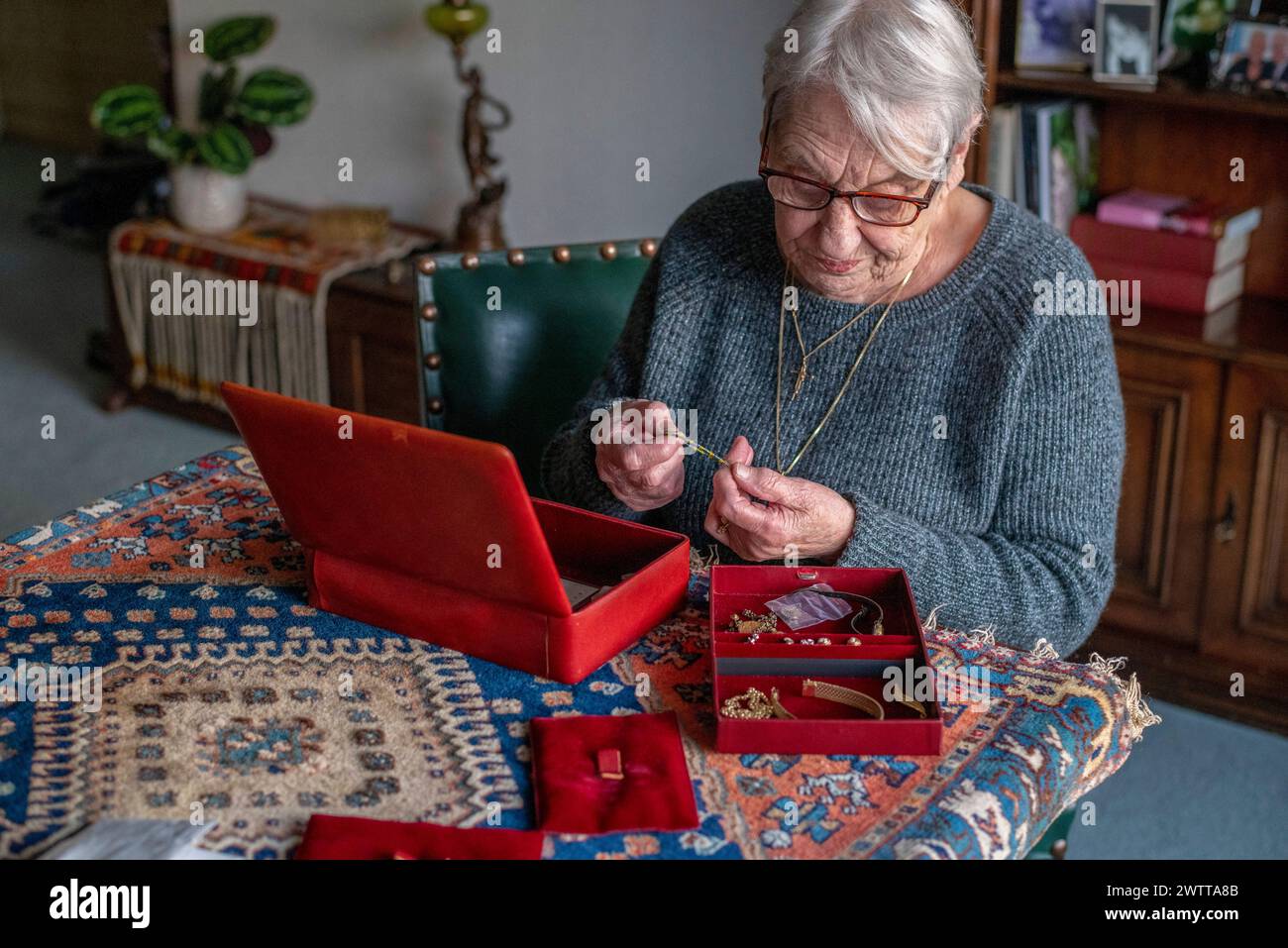 Ältere Frau, die Erinnerungen mit ihrer Schmuckschatulle schätze. Stockfoto