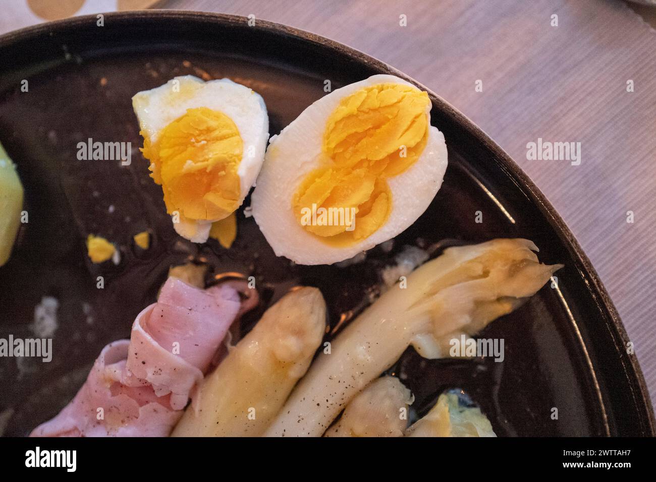 Ein Teller mit klassischem Spargel mit Schinken in Scheiben und gekochten Eiern Stockfoto