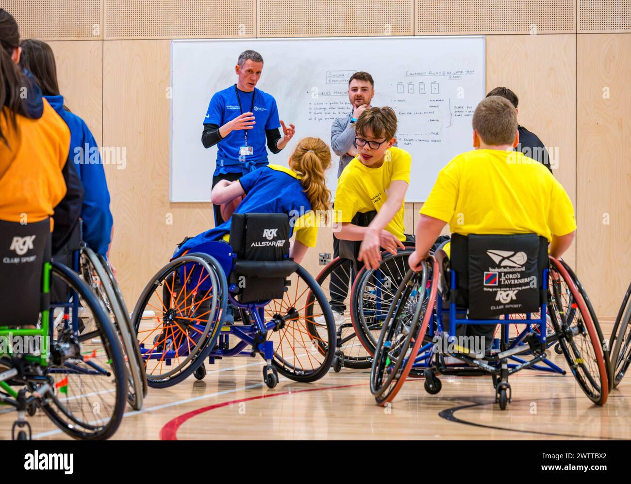 Winchburgh Academy, West Lothian, Schottland, Großbritannien, 19. März 2024. Parasport Festival für Kinder mit Behinderungen: Scottish Disability Sport veranstaltet eine Reihe landesweiter Veranstaltungen, um Jugendlichen mit körperlichen Behinderungen, Hörverlust und Sehstörungen die Möglichkeit zu bieten, eine breite Palette von Sportarten von qualifizierten Trainern vor Ort auszuprobieren. Abbildung: Kinder versuchen Rollstuhlbasketball, auch wenn sie keinen Rollstuhl benutzen. Quelle: Sally Anderson/Alamy Live News Stockfoto