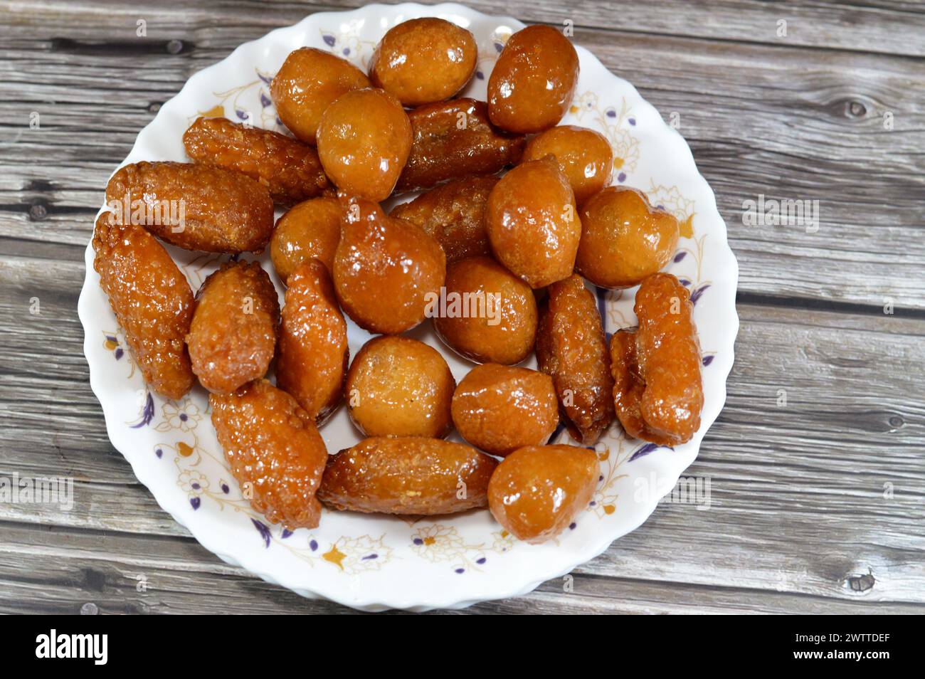 Verschiedene Desserts aus dem Nahen Osten von Zalabia, eine Art von gebratenem Teig aus dem Nahen Osten, ähnlich der eines Donuts, und ägyptische Zainab-Finger oder glasiert Stockfoto