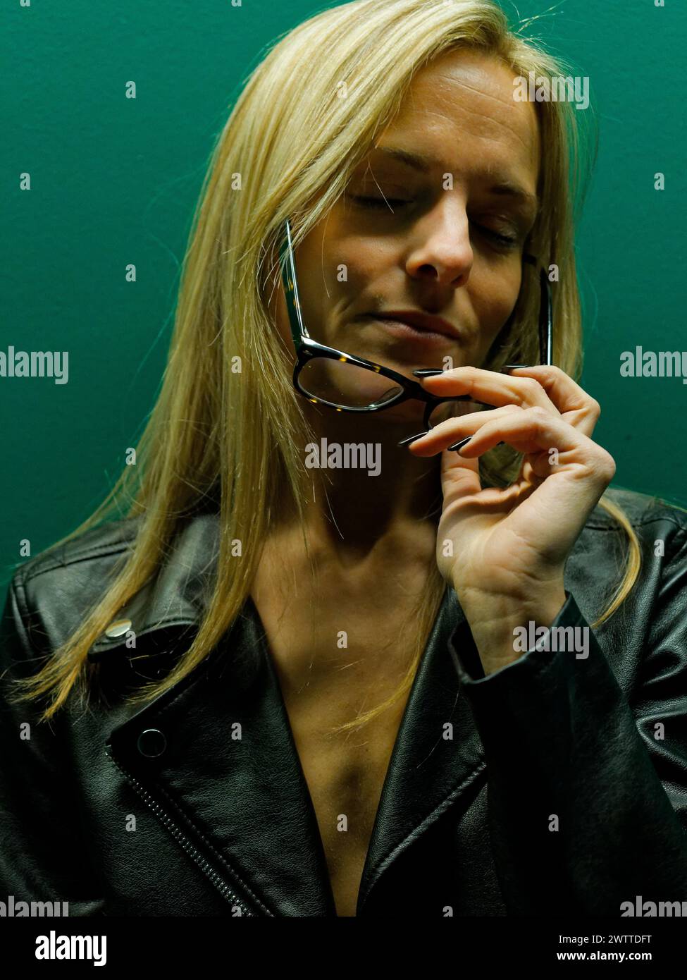 Frau, die ihre Brille hielt, verlor in Gedanken Stockfoto