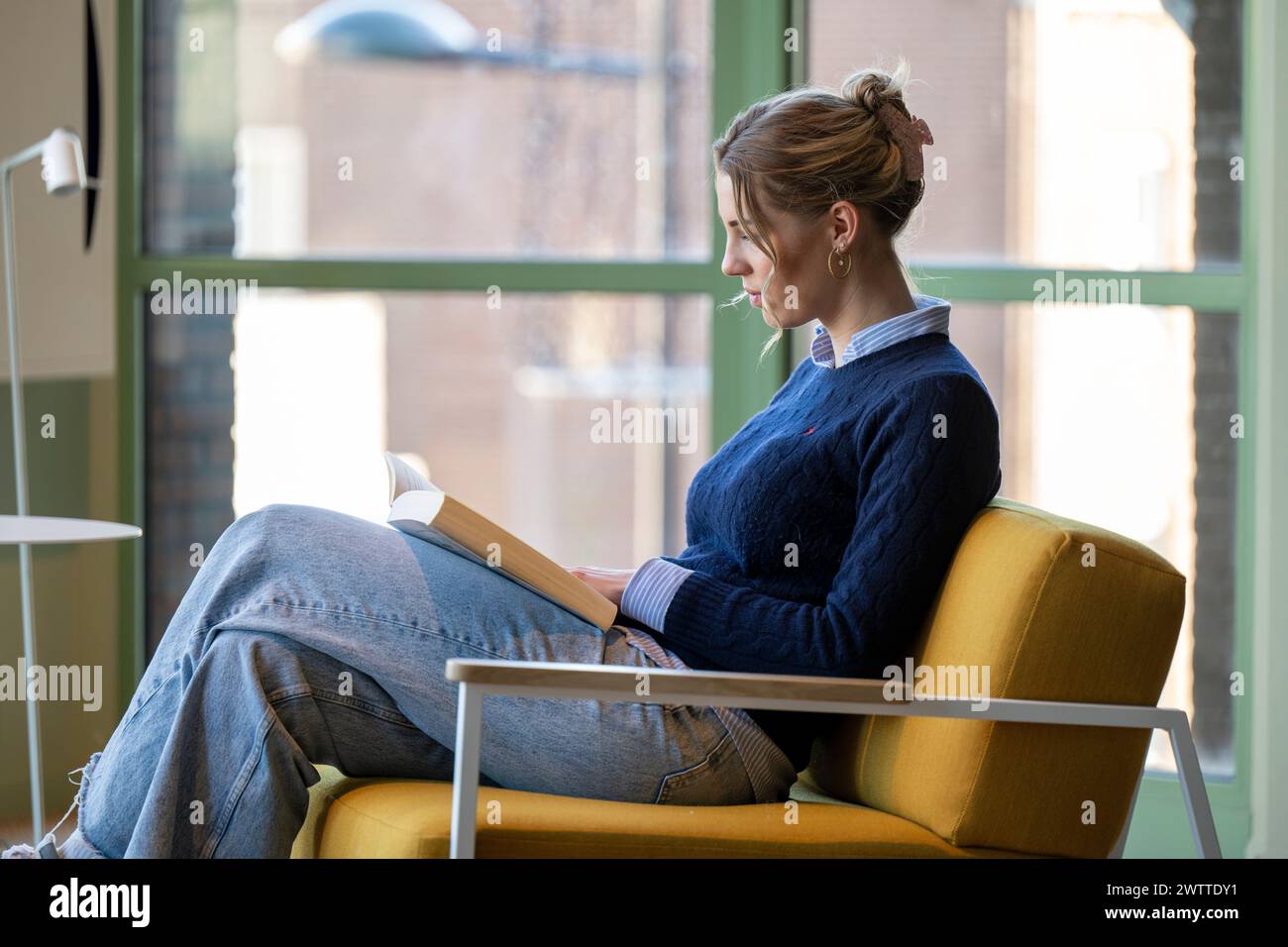 Ein Moment der Ruhe Frau, vertieft in ein Buch an einem sonnigen Nachmittag. Stockfoto