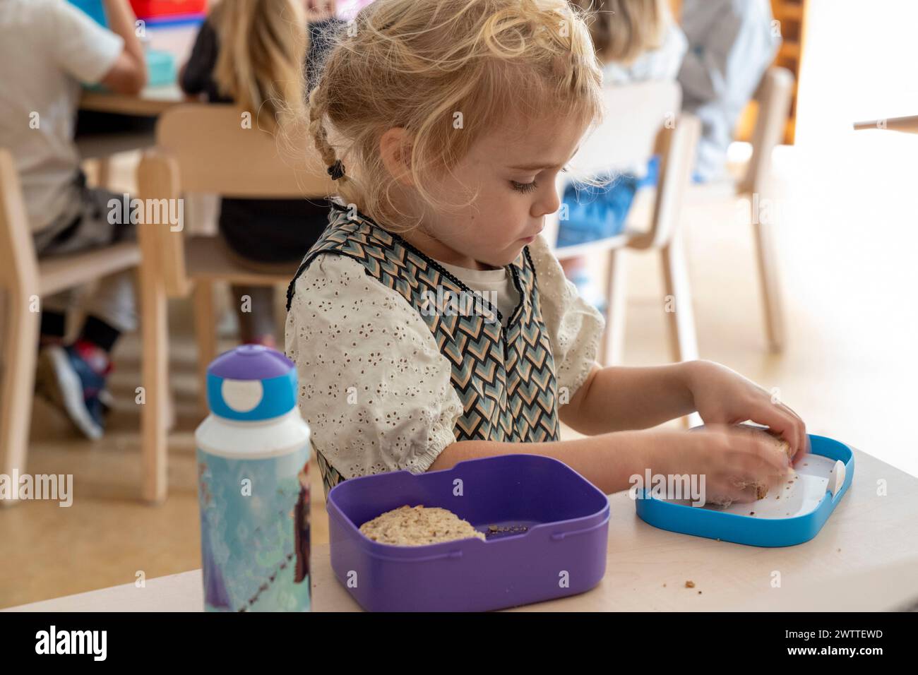 Das kleine Mädchen konzentrierte sich auf ihre Mittagszeit in der Vorschule Stockfoto
