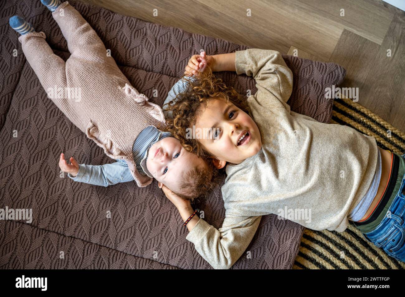 Zwei Geschwister genießen einen verspielten Moment an einem gemütlichen Nachmittag zu Hause. Stockfoto