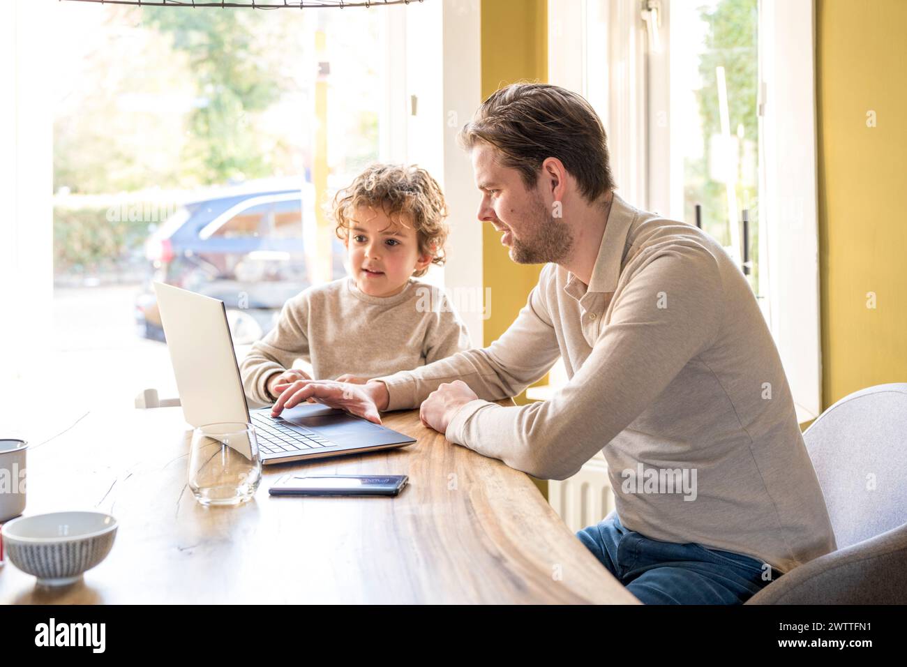 Vater und Sohn genießen die Zeit zusammen mit einem Laptop zu Hause Stockfoto
