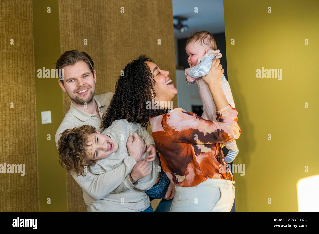 Fröhlicher Familienmoment mit verspieltem Kleinkind und Baby Stockfoto