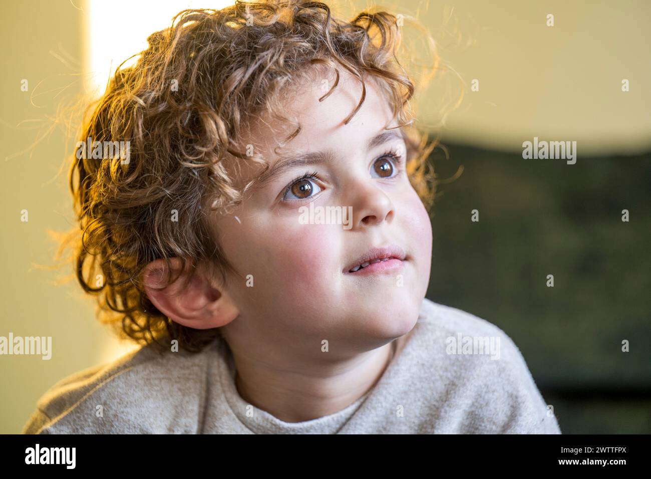 Neugieriges Kind, das mit einem Gefühl des Staunens auf das Licht blickt Stockfoto