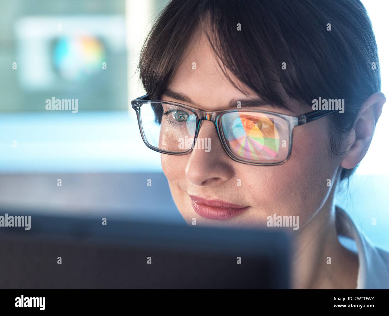 Professionelle Frauen entwerfen ein Tortendiagramm auf einem Computer, um Unternehmensstatistiken zu veranschaulichen. Stockfoto