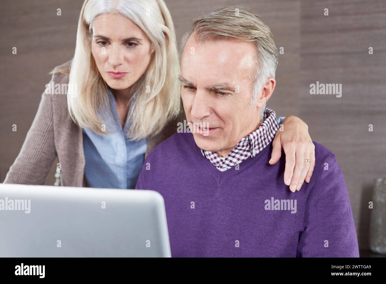 Zwei Erwachsene, die auf einen Laptop-Bildschirm schauen Stockfoto