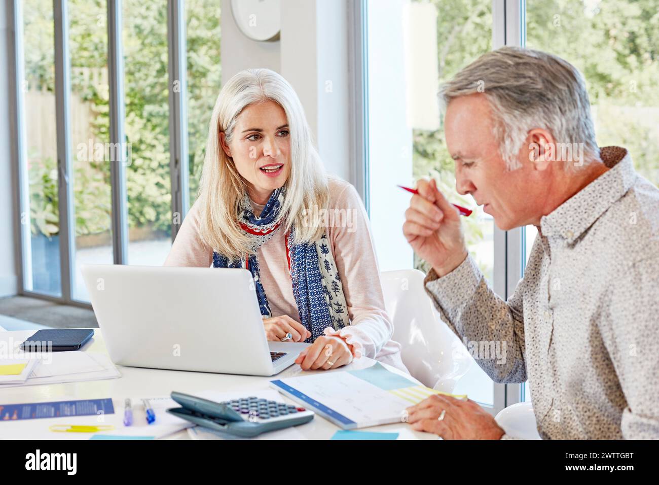 Zwei Erwachsene diskutieren über die Arbeit in einem hellen Büro Stockfoto