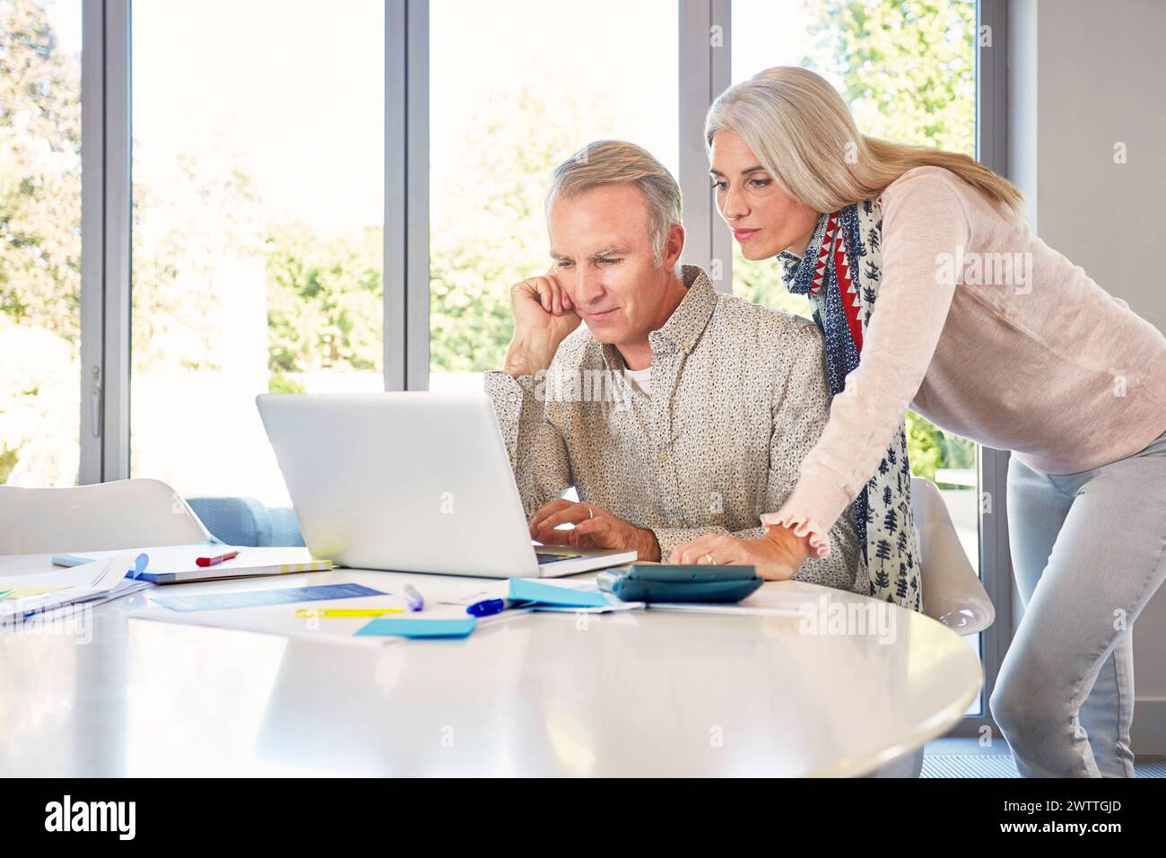 Zwei Erwachsene arbeiten zusammen an einem Laptop Stockfoto