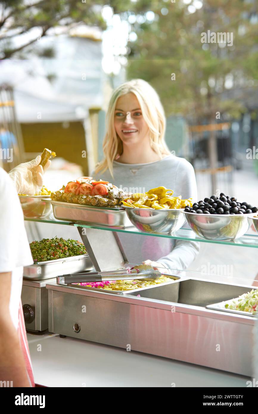 Frau, die Essen am Buffet auswählt Stockfoto