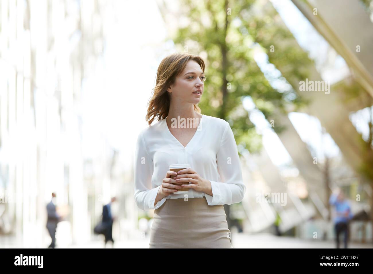Frau, die mit Kaffee in der Stadt läuft Stockfoto