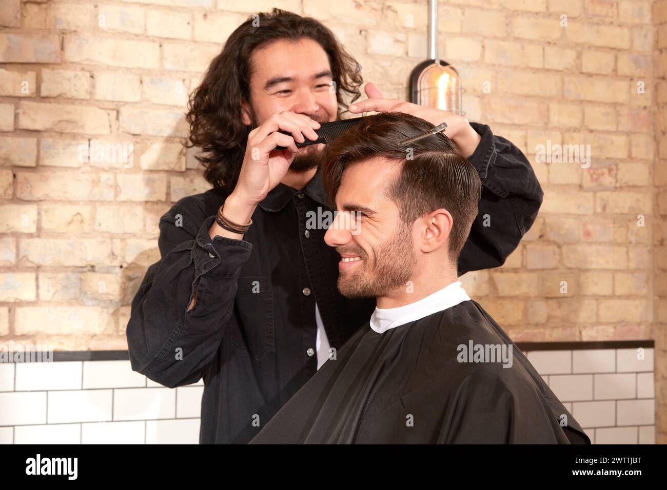 Friseur, der einem Mann einen Haarschnitt gibt Stockfoto