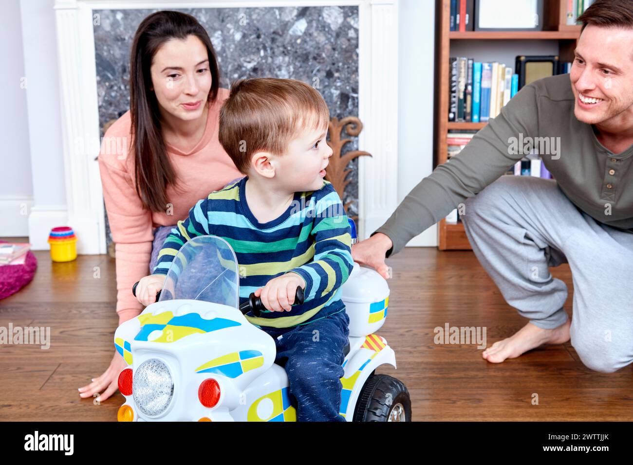 Familie spielt mit einem Spielzeugauto im Haus Stockfoto