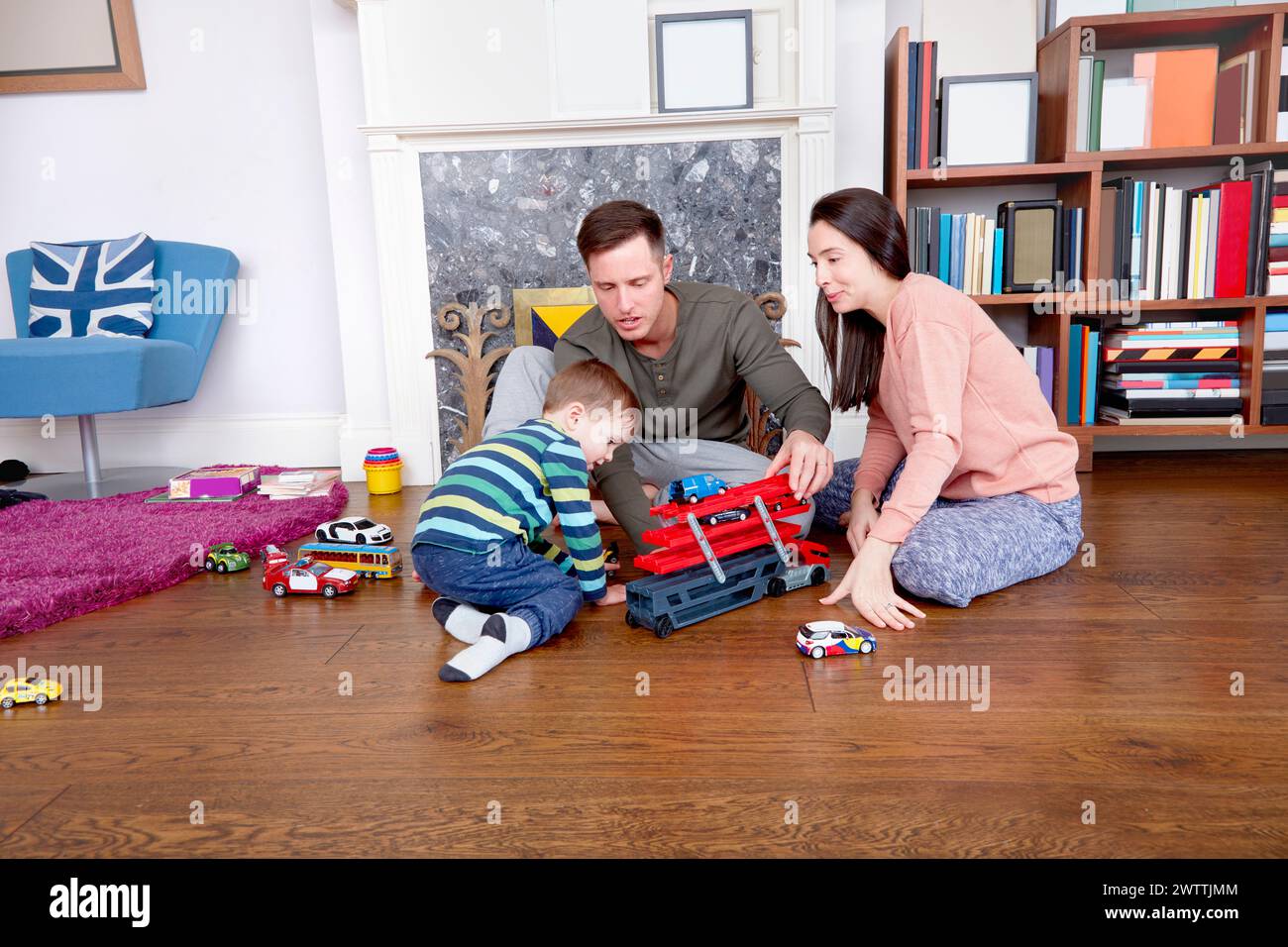 Familie spielt mit Spielzeug auf dem Wohnzimmerboden Stockfoto