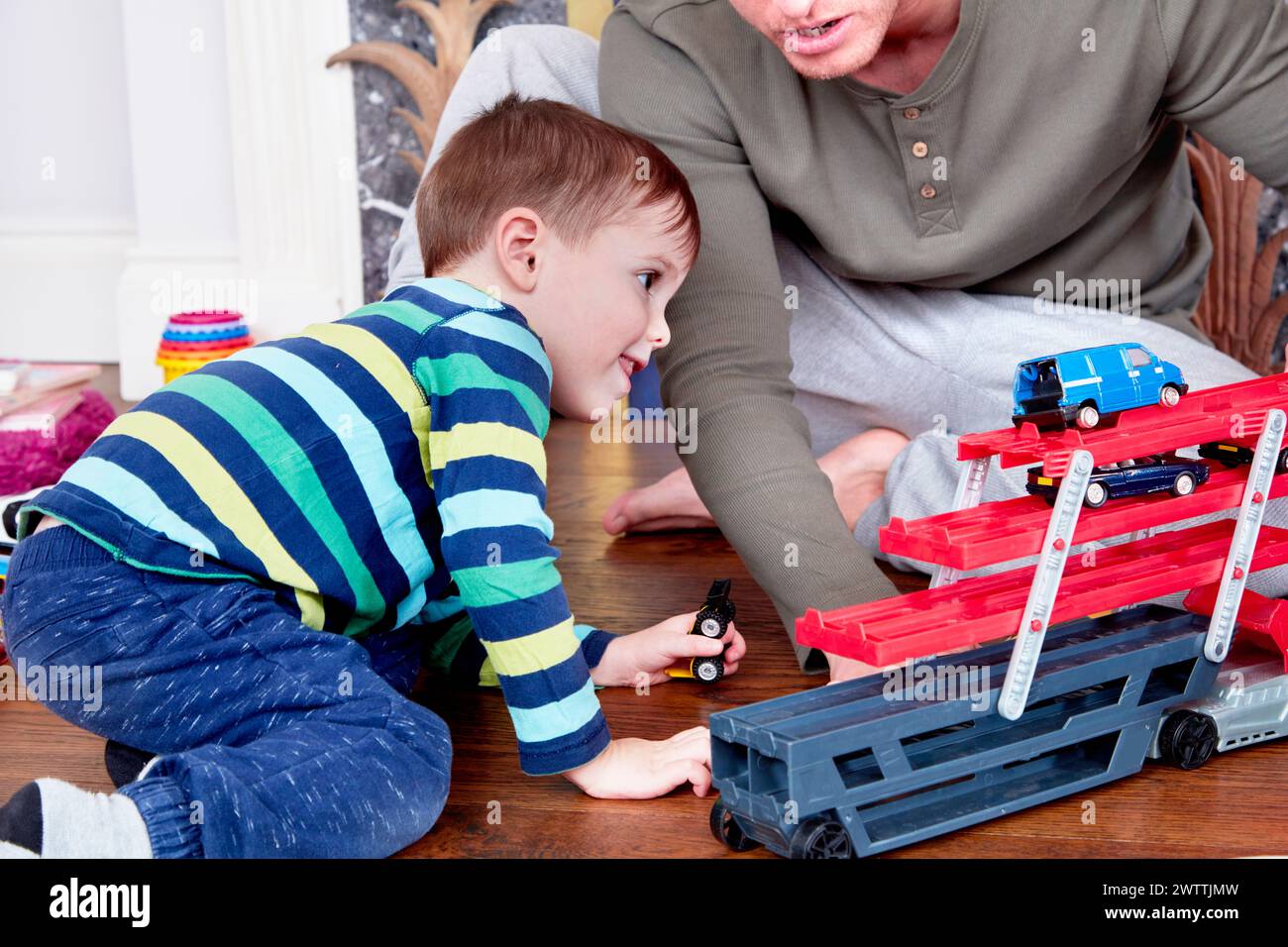 Kind, das mit Spielzeugautos auf einer Rennbahn spielt Stockfoto