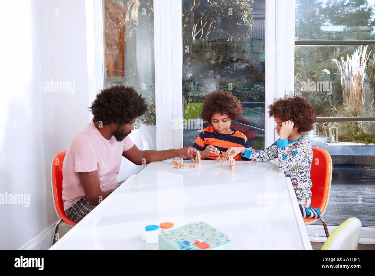 Familie spielt gemeinsam ein Spiel an einem Tisch Stockfoto