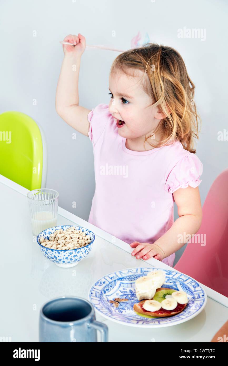 Kleinkind frühstückt am Tisch Stockfoto
