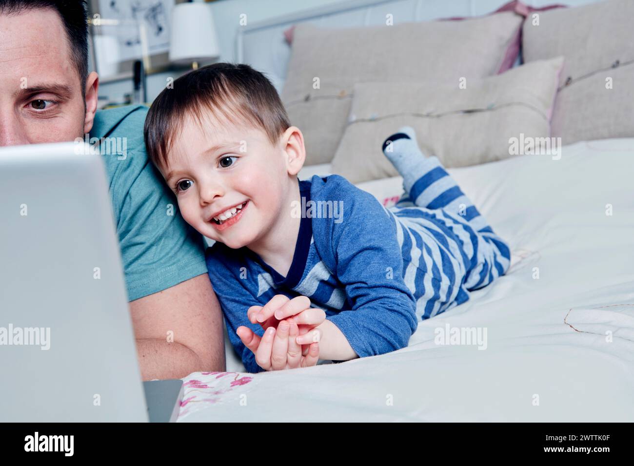 Kleinkind und Eltern genießen die Zeit mit einem Laptop Stockfoto