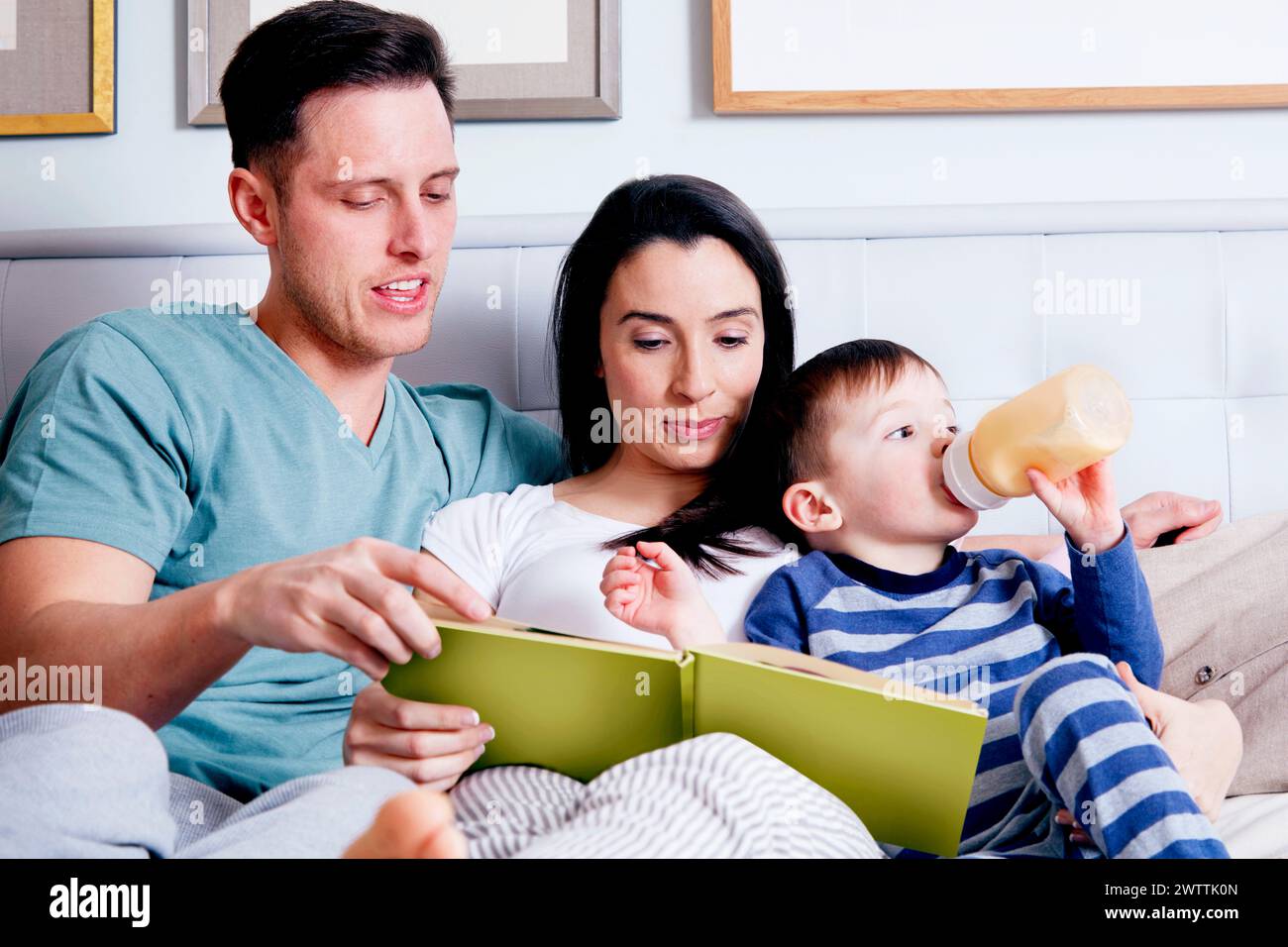 Familie liest ein Buch zusammen auf einer Couch Stockfoto