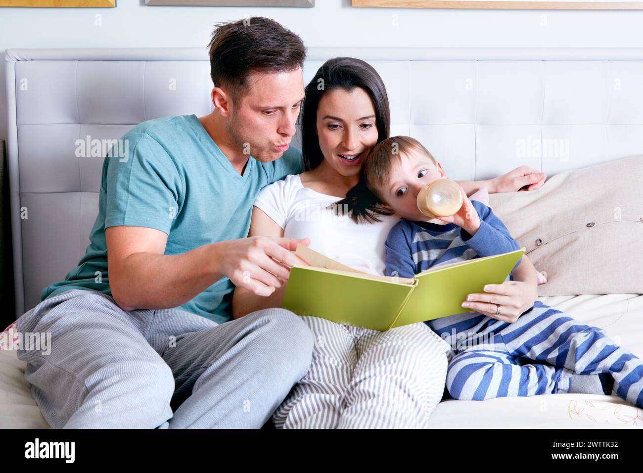Familie genießt ein Buch im Bett Stockfoto