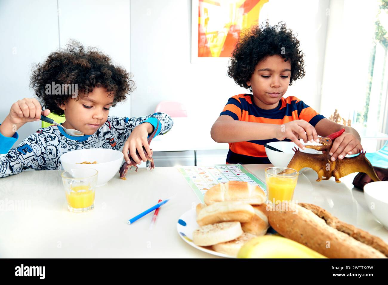 Kinder frühstücken und spielen am Tisch Stockfoto