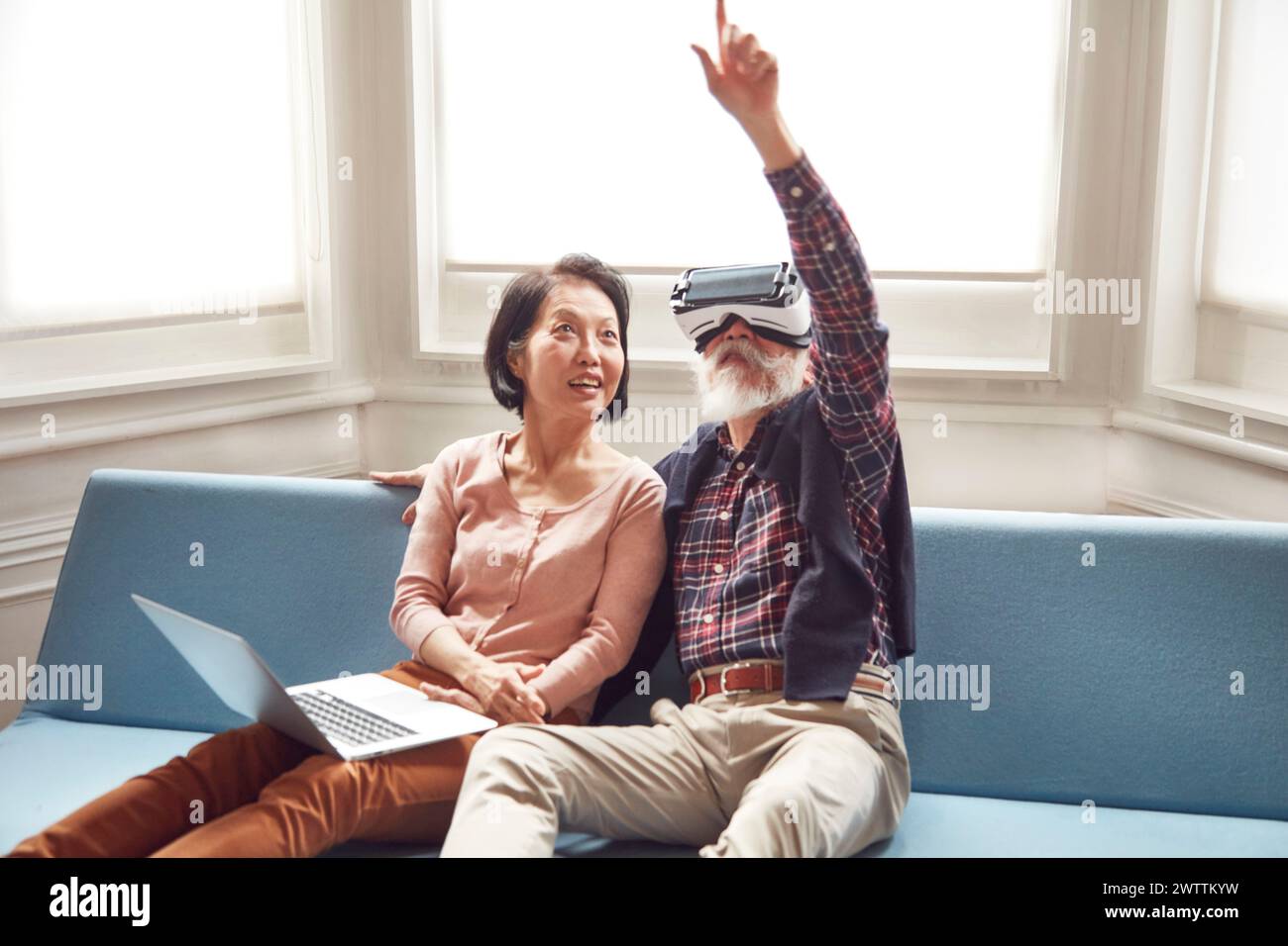 Seniorenpaar mit einem VR-Headset in Innenräumen. Stockfoto