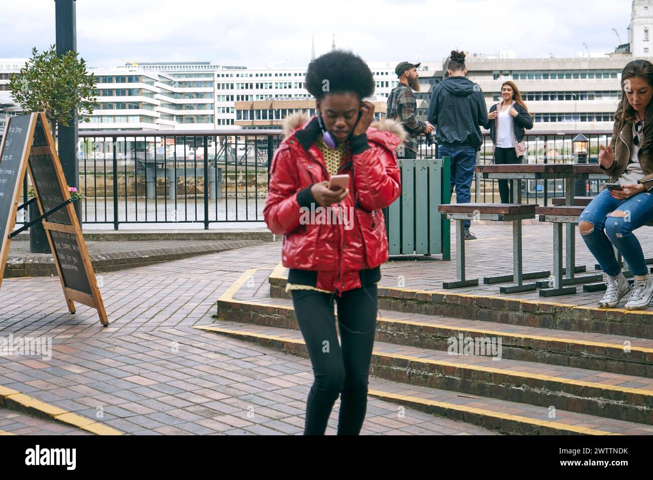 Person läuft, während sie auf ein Telefon blickt Stockfoto
