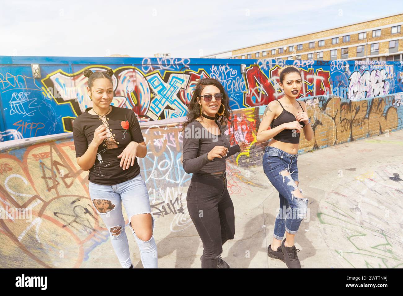 Drei Frauen posieren vor einer Graffiti-Wand Stockfoto