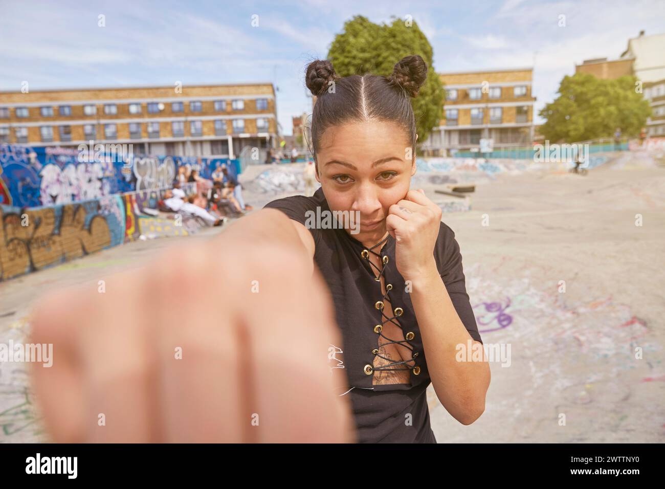 Frau posiert mit einer spielerischen Faust vor der Kamera Stockfoto