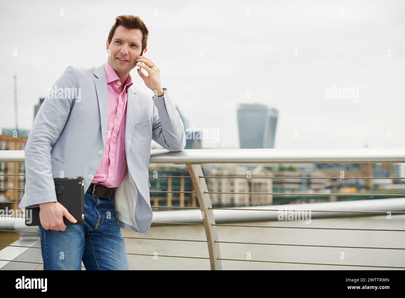 Mann, der am Telefon spricht, mit Stadtbild im Hintergrund Stockfoto