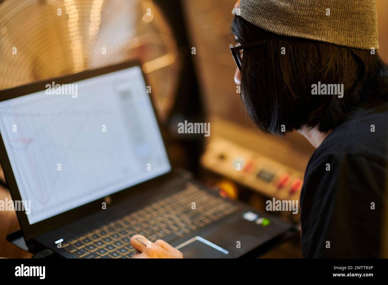 Person, die an einem Laptop mit Diagrammen arbeitet Stockfoto