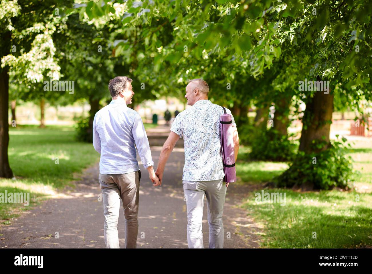 Zwei Männer gehen Hand in Hand in einem Park Stockfoto